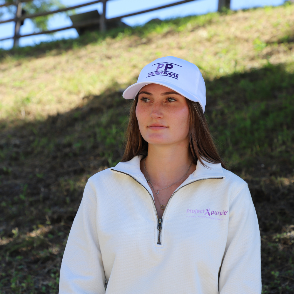 girl with white hat and project purple sweater