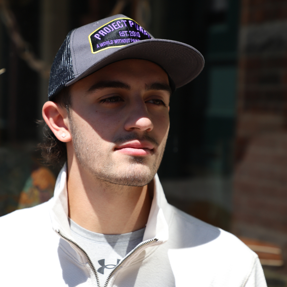 boy wearing black project purple hat