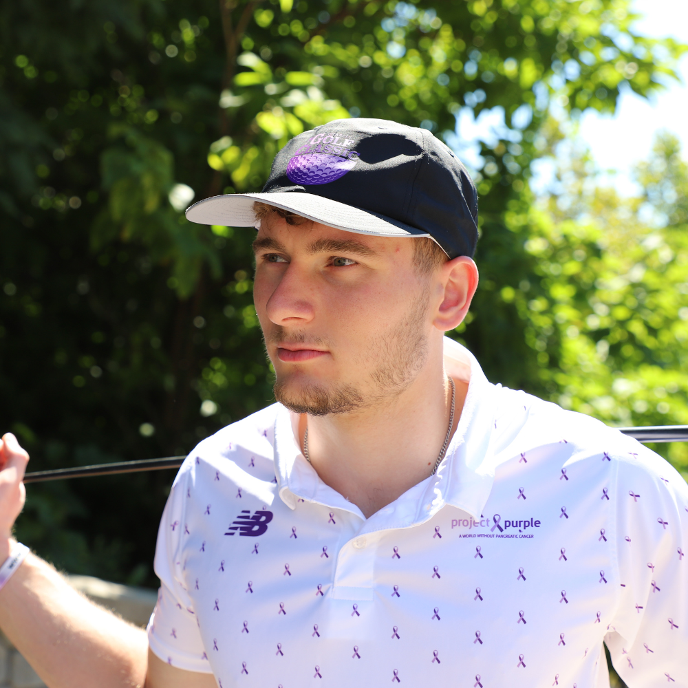 boy holding golf club and white polo