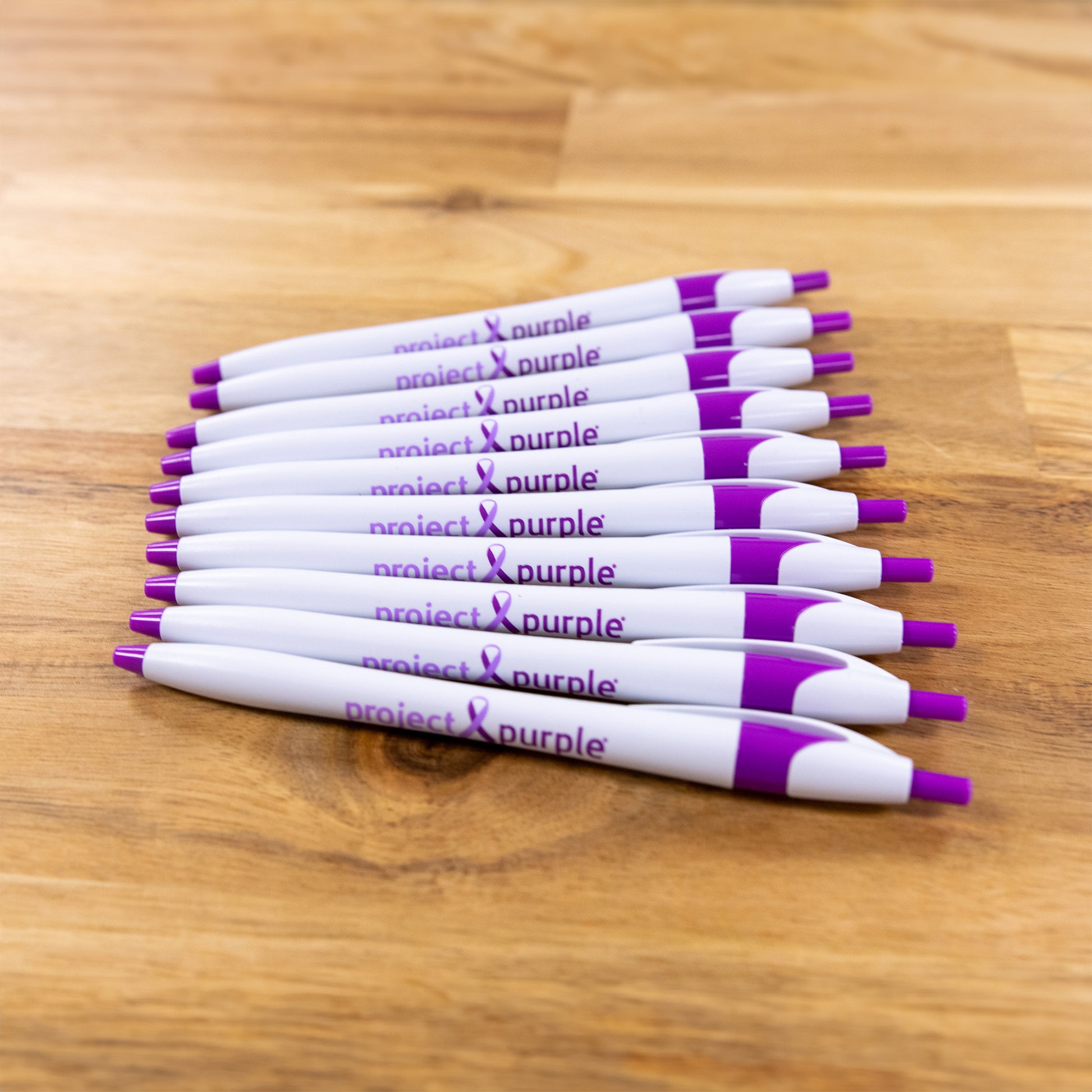 project purple pens on wood table