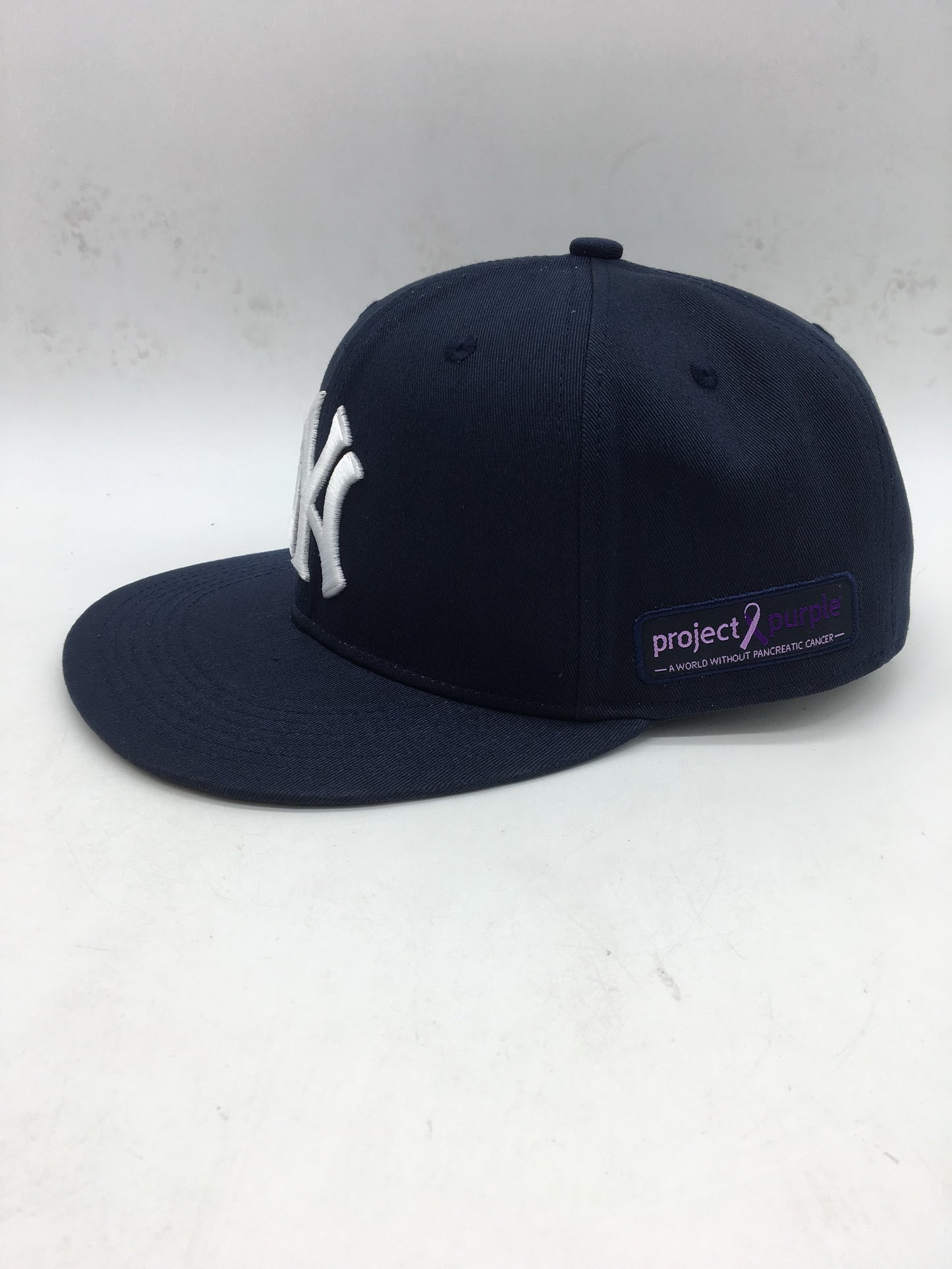Side view of Yankee hat with Project purple logo